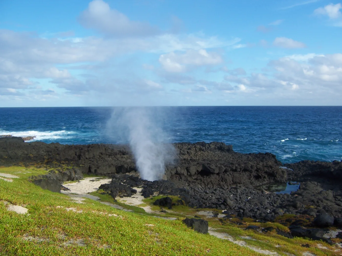 Meerwasser schießt aus dem Vulkangestein des Blasloch auf der Insel Ilhéu das Rolas südlich von São Tomé
